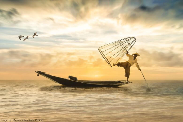 Fisherman balancing on a boat