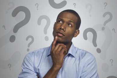 Man looking thoughtful with question marks in the background