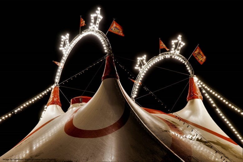 circus big top lit up against night sky