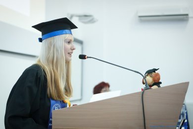 Female graduate student at a podium giving a speech