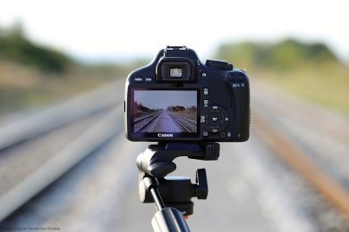 Camera on a tripod pointing down a railway track