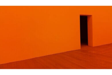 an orange wall with an open door on the right