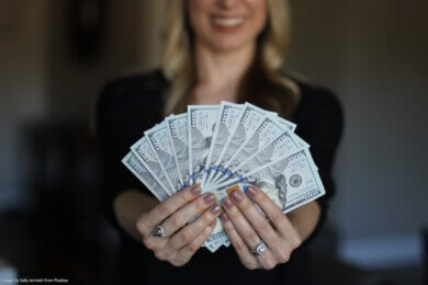 woman holding a fan of money notes