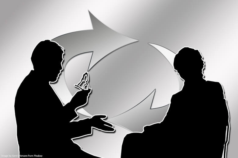 B&W illustration of two people exchanging feedback