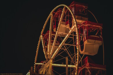 Ferris wheel with Christmas decoration against a dark sky